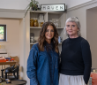 Sarah and Patricia stand in front of a Maven sign inside the Maven shop